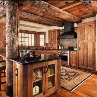 Medium sized rustic u-shaped kitchen in Detroit with shaker cabinets, medium wood cabinets, multi-coloured splashback, matchstick tiled splashback, stainless steel appliances, medium hardwood flooring, a breakfast bar and composite countertops.
