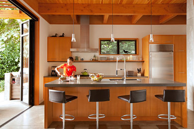 Foto de cocina contemporánea con fregadero bajoencimera, armarios con paneles lisos, puertas de armario de madera oscura, salpicadero blanco, suelo de cemento y una isla