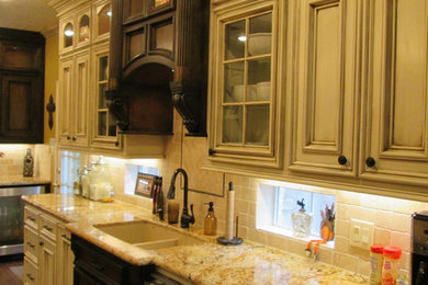 ヒューストンにある高級なトラディショナルスタイルのおしゃれなキッチン (アンダーカウンターシンク、落し込みパネル扉のキャビネット、ヴィンテージ仕上げキャビネット、御影石カウンター、白いキッチンパネル、サブウェイタイルのキッチンパネル、シルバーの調理設備) の写真