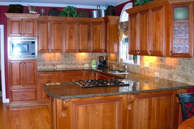 Inspiration for a craftsman l-shaped kitchen remodel in Atlanta with louvered cabinets, medium tone wood cabinets, granite countertops, beige backsplash and ceramic backsplash