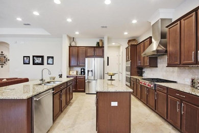 Inspiration for a large timeless galley kitchen remodel in Austin with shaker cabinets, brown cabinets and two islands