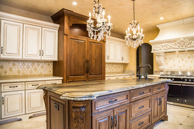 Large elegant u-shaped marble floor and beige floor eat-in kitchen photo in San Francisco with a farmhouse sink, raised-panel cabinets, white cabinets, granite countertops, paneled appliances, an island, beige backsplash and ceramic backsplash