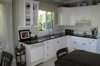Mid-sized minimalist l-shaped eat-in kitchen photo in Seattle with raised-panel cabinets, white cabinets and an island