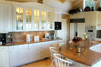 Mid-sized trendy l-shaped porcelain tile eat-in kitchen photo in San Francisco with an integrated sink, white cabinets, granite countertops, white backsplash, white appliances and an island