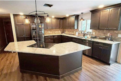 Inspiration for a mid-sized transitional l-shaped laminate floor and brown floor eat-in kitchen remodel in Boston with an undermount sink, shaker cabinets, dark wood cabinets, granite countertops, brown backsplash, mosaic tile backsplash, stainless steel appliances, an island and beige countertops