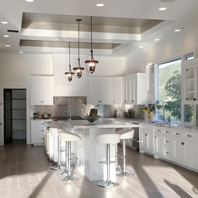 Inspiration for a mid-sized contemporary u-shaped medium tone wood floor eat-in kitchen remodel in Los Angeles with a double-bowl sink, raised-panel cabinets, white cabinets, granite countertops, white backsplash, mosaic tile backsplash, stainless steel appliances and an island
