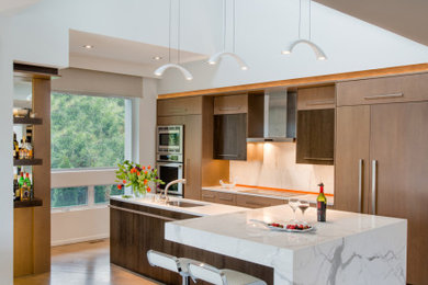 Eat-in kitchen - large contemporary l-shaped brown floor and light wood floor eat-in kitchen idea in DC Metro with an undermount sink, flat-panel cabinets, medium tone wood cabinets, white backsplash, paneled appliances, an island, white countertops, marble countertops and marble backsplash