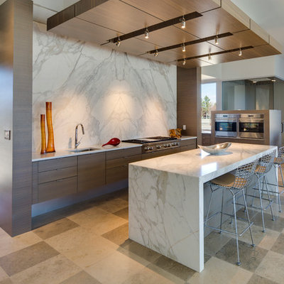 Trendy open concept kitchen photo in Albuquerque with flat-panel cabinets, marble countertops, stone slab backsplash, stainless steel appliances, an undermount sink, dark wood cabinets, white backsplash and an island