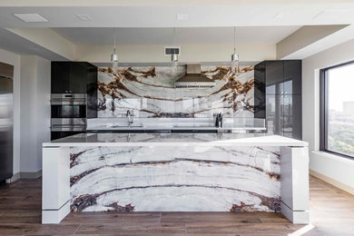 Kitchen - modern kitchen idea in Dallas with flat-panel cabinets, stone slab backsplash and an island