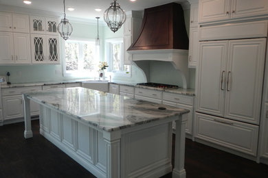 Inspiration for a large timeless l-shaped laminate floor and brown floor eat-in kitchen remodel in Other with a farmhouse sink, raised-panel cabinets, white cabinets, granite countertops, stainless steel appliances and an island