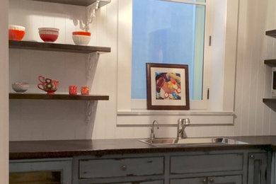 ロサンゼルスにある小さなラスティックスタイルのおしゃれなL型キッチン (アンダーカウンターシンク、落し込みパネル扉のキャビネット、青いキャビネット、木材カウンター、無垢フローリング) の写真