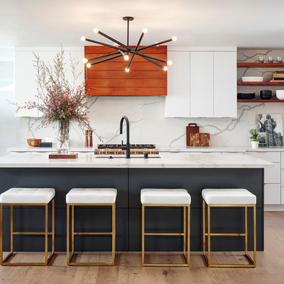 Inspiration for a large contemporary galley light wood floor and beige floor kitchen remodel in San Diego with an undermount sink, flat-panel cabinets, white cabinets, marble countertops, white backsplash, marble backsplash, stainless steel appliances, an island and white countertops