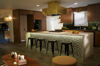 Photo of a medium sized midcentury l-shaped open plan kitchen in Sacramento with a submerged sink, flat-panel cabinets, medium wood cabinets, engineered stone countertops, black splashback, stone tiled splashback, black appliances, medium hardwood flooring, an island and brown floors.