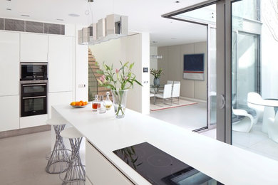 Contemporary kitchen in London with flat-panel cabinets and white cabinets.