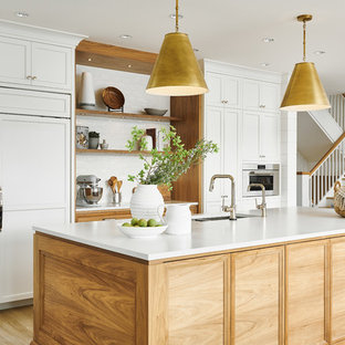 Design ideas for a large beach style l-shaped eat-in kitchen in Vancouver with a double-bowl sink, shaker cabinets, white cabinets, quartzite benchtops, white splashback, ceramic splashback, stainless steel appliances, vinyl floors, with island, beige floor and white benchtop.