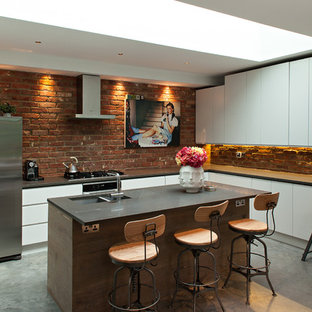 Design ideas for an industrial l-shaped kitchen in London with a double-bowl sink, flat-panel cabinets, white cabinets, stainless steel appliances, concrete floors and with island.