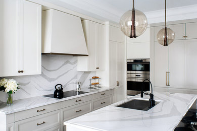 Inspiration for a mid-sized transitional l-shaped eat-in kitchen remodel in New York with a drop-in sink, shaker cabinets, white cabinets, quartz countertops, white backsplash, stone slab backsplash, stainless steel appliances and an island
