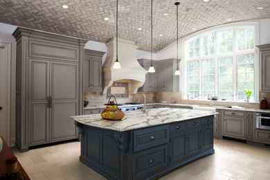 Large transitional l-shaped travertine floor eat-in kitchen photo in New York with a farmhouse sink, raised-panel cabinets, gray cabinets, quartzite countertops, beige backsplash, ceramic backsplash, stainless steel appliances and an island