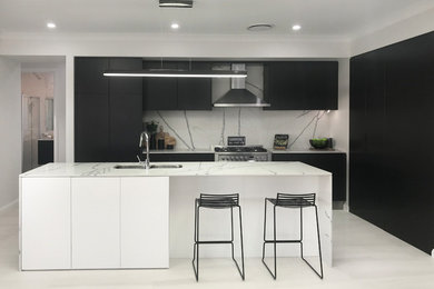 シドニーにあるコンテンポラリースタイルのおしゃれなII型キッチン (黒いキャビネット) の写真