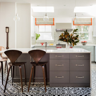 Foto de cocina en U, tradicional renovada, grande, abierta, con fregadero bajoencimera, armarios estilo shaker, puertas de armario grises, encimera de cuarzo compacto, salpicadero blanco, salpicadero de azulejos de cerámica, electrodomésticos de acero inoxidable, suelo de baldosas de porcelana, una isla, suelo beige y encimeras blancas
