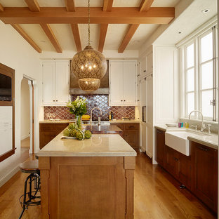 Foto de cocina en L, mediterránea, grande, cerrada, con fregadero sobremueble, armarios con rebordes decorativos, puertas de armario blancas, encimera de piedra caliza, electrodomésticos con paneles, suelo de madera en tonos medios, una isla, salpicadero marrón y suelo marrón