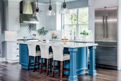 Inspiration for a mid-sized timeless l-shaped dark wood floor and brown floor eat-in kitchen remodel in Austin with a single-bowl sink, shaker cabinets, white cabinets, quartz countertops, white backsplash, ceramic backsplash, stainless steel appliances, an island and white countertops