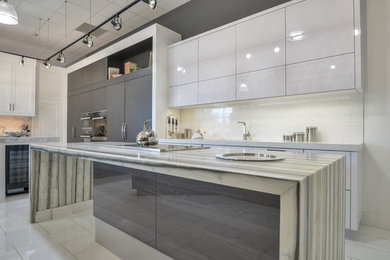 Open concept kitchen - mid-sized contemporary l-shaped porcelain tile and white floor open concept kitchen idea in Toronto with an undermount sink, flat-panel cabinets, white cabinets, marble countertops, white backsplash, stone slab backsplash, paneled appliances, an island and gray countertops