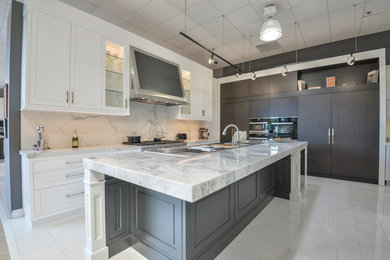 Inspiration for a large transitional u-shaped white floor open concept kitchen remodel in Toronto with an undermount sink, shaker cabinets, white cabinets, quartzite countertops, white backsplash, stone slab backsplash, stainless steel appliances, an island and white countertops