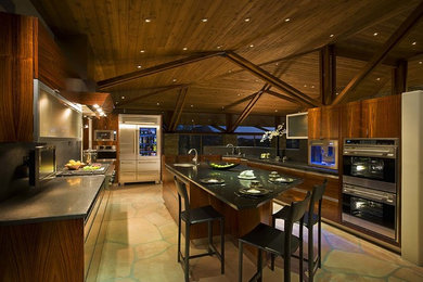 Example of a large trendy galley eat-in kitchen design with flat-panel cabinets, an island, dark wood cabinets, quartz countertops, an undermount sink, black backsplash, stone slab backsplash and stainless steel appliances