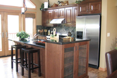 Idée de décoration pour une cuisine américaine linéaire chalet en bois brun de taille moyenne avec un évier encastré, un placard avec porte à panneau surélevé, un électroménager en acier inoxydable, un sol en bois brun et îlot.