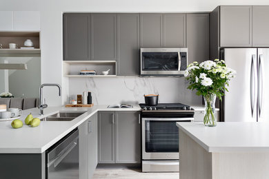 Eat-in kitchen - scandinavian l-shaped laminate floor and gray floor eat-in kitchen idea in Vancouver with an undermount sink, shaker cabinets, gray cabinets, quartz countertops, white backsplash, porcelain backsplash, stainless steel appliances, an island and white countertops