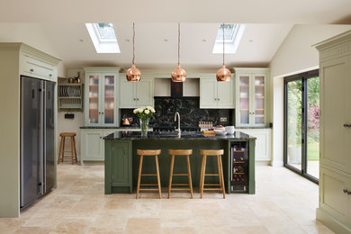 エセックスにある広いコンテンポラリースタイルのおしゃれなキッチン (緑のキャビネット、御影石カウンター、黒いキッチンパネル、シルバーの調理設備) の写真
