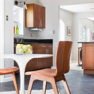 Immagine di una piccola cucina american style con ante in stile shaker, ante in legno scuro, top in granito, paraspruzzi nero, paraspruzzi in lastra di pietra, elettrodomestici in acciaio inossidabile, pavimento in ardesia, pavimento nero e top nero