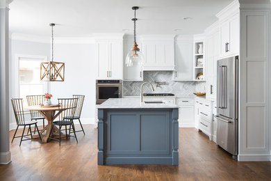 Inspiration for a farmhouse medium tone wood floor and brown floor kitchen remodel in Atlanta with beaded inset cabinets, white cabinets, marble countertops, marble backsplash and stainless steel appliances