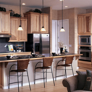 Inspiration for a mid-sized asian l-shaped open plan kitchen in Seattle with a double-bowl sink, raised-panel cabinets, light wood cabinets, solid surface benchtops, black splashback, ceramic splashback, stainless steel appliances, light hardwood floors and with island.