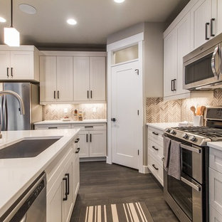 Imagen de cocina en L, tradicional renovada, grande, abierta, con fregadero bajoencimera, armarios estilo shaker, puertas de armario blancas, salpicadero marrón, electrodomésticos de acero inoxidable, suelo de madera oscura, una isla, encimera de cuarzo compacto, salpicadero con mosaicos de azulejos y suelo marrón