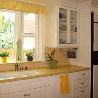 Mid-sized eclectic galley separate kitchen in Los Angeles with a double-bowl sink, shaker cabinets, white cabinets, quartz benchtops, yellow splashback, stone tile splashback, stainless steel appliances, medium hardwood floors and no island.