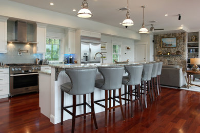 Inspiration for a large coastal l-shaped dark wood floor and brown floor open concept kitchen remodel in Boston with an undermount sink, shaker cabinets, white cabinets, granite countertops, gray backsplash, subway tile backsplash, stainless steel appliances, an island and gray countertops