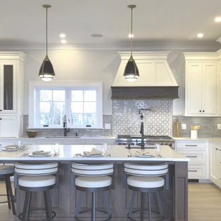Large transitional l-shaped kitchen pantry in Boston with an integrated sink, recessed-panel cabinets, white cabinets, quartz benchtops, brown splashback, ceramic splashback, stainless steel appliances, light hardwood floors, with island and yellow benchtop.