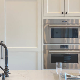 Design ideas for a large transitional l-shaped kitchen pantry in Boston with an integrated sink, recessed-panel cabinets, white cabinets, quartz benchtops, brown splashback, ceramic splashback, stainless steel appliances, light hardwood floors, with island and yellow benchtop.