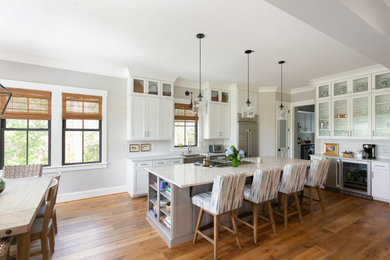 Large transitional l-shaped dark wood floor kitchen photo in Charleston with a farmhouse sink, shaker cabinets, gray cabinets, recycled glass countertops and an island