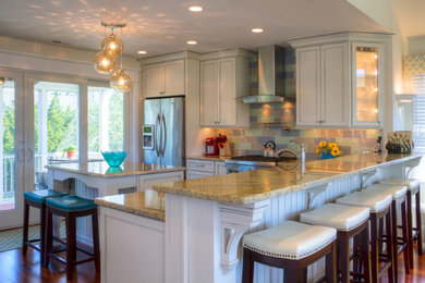 Inspiration for a mid-sized coastal l-shaped dark wood floor eat-in kitchen remodel in Philadelphia with an undermount sink, light wood cabinets, granite countertops, multicolored backsplash, glass tile backsplash, stainless steel appliances and an island