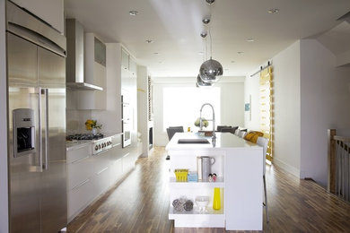 Photo of a large contemporary u-shaped kitchen/diner in Calgary with flat-panel cabinets, white cabinets, laminate countertops, white splashback, porcelain splashback and an island.