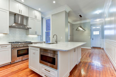 Inspiration for a contemporary l-shaped medium tone wood floor and orange floor eat-in kitchen remodel in DC Metro with a single-bowl sink, shaker cabinets, white cabinets, quartz countertops, white backsplash, subway tile backsplash, stainless steel appliances, an island and white countertops
