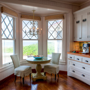 Immagine di una cucina tropicale di medie dimensioni con top in legno, lavello stile country, ante in stile shaker, ante bianche, paraspruzzi verde, paraspruzzi con piastrelle di vetro, parquet scuro, nessuna isola e pavimento marrone