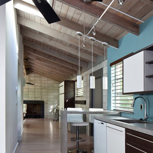 Idee per una cucina design di medie dimensioni con ante lisce, ante bianche, elettrodomestici bianchi, lavello sottopiano, top in cemento, paraspruzzi blu, parquet chiaro, penisola e top grigio
