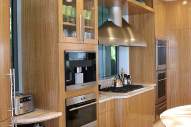 Foto de cocina contemporánea grande abierta con armarios con paneles lisos, puertas de armario de madera oscura, encimera de cuarcita, electrodomésticos con paneles, dos o más islas y encimeras blancas