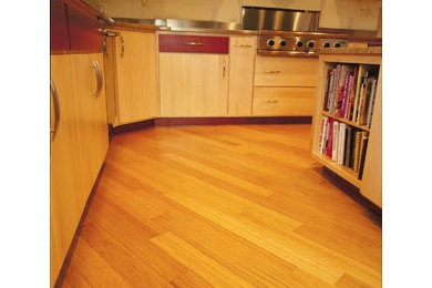 Example of a trendy bamboo floor eat-in kitchen design in Other with flat-panel cabinets, red cabinets, granite countertops and an island