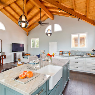 Esempio di un'ampia cucina stile marinaro con lavello stile country, ante in stile shaker, ante bianche, top in quarzo composito, paraspruzzi multicolore, paraspruzzi con piastrelle di vetro, elettrodomestici in acciaio inossidabile, parquet scuro e isola