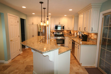 Bild på ett mellanstort, avskilt vintage beige beige l-kök, med en undermonterad diskho, luckor med upphöjd panel, vita skåp, granitbänkskiva, beige stänkskydd, stänkskydd i stenkakel, rostfria vitvaror, travertin golv, en köksö och beiget golv